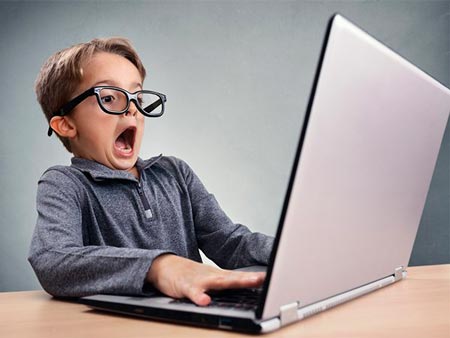 Menino assustado usando notebook 